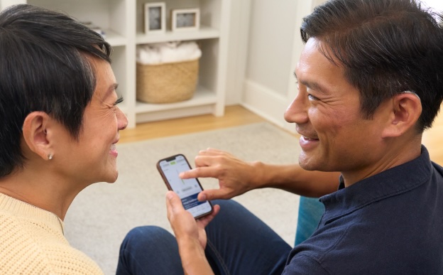 Couple reviewing hearing options on a phone